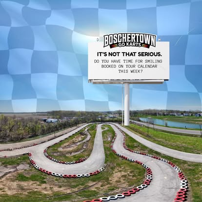 A winding go-kart track in St. Charles is surrounded by grass under a blue sky. A large billboard reads Boschertown Go Karts. It’s not that serious—do you have time for smiling booked on your calendar this week?.
