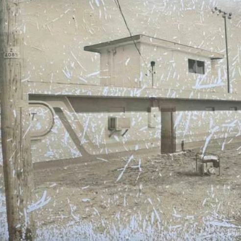 A weathered, scratched photo of a small, plain building with a flat roof in St. Charles. A utility pole stands in the foreground, and a single chair sits on barren ground beside the structure, evoking memories of old Boschertown Go Karts days.